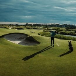 Golfer hitting an iron shot from the fairway just after impact